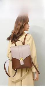 Detailed back view of a minimalist cream and brown leather backpack with gold buckle hardware