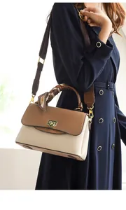 Détail d'un sac en cuir bicolore avec poignée en foulard et bandoulière large