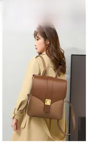Side view of woman in trench coat wearing retro brown patchwork leather backpack