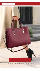 Detail view of burgundy leather tote with metal hardware and logo in street setting