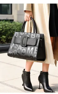 Close-up of black lychee leather tote bag featuring buckle strap and ROSAOME letter print