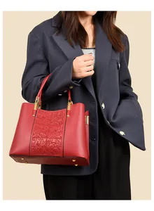 Detailed macro view of red bridal handbag with embossed floral patterns and gold hardware