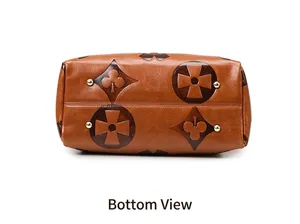 Detailed bottom view of brown embossed leather bucket bag with protective metal studs