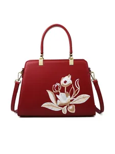 Elegante borsa a mano rosso intenso con ricamo floreale bianco e dettagli dorati
