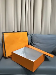 Detalle de la caja de regalo naranja de lujo y bolsa con bordes negros a juego