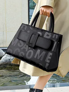 Large black pebbled leather tote bag with embossed letters and metal buckle for women