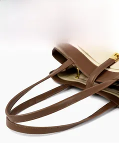 Close-up of dual leather handles and fine stitching on the canvas tote bag