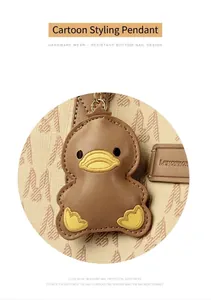 Detailed close-up of a brown cartoon duck charm on a handbag with premium stitching