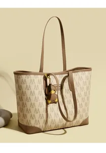 Detail of monogrammed tote bag with brown leather trim and cute duck charm