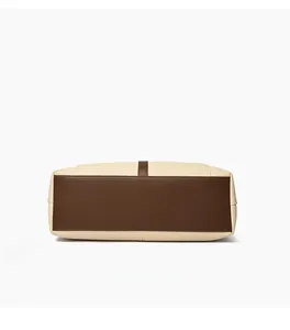 Detail view showing durable canvas and brown leather stitching on the tote bag bottom
