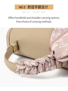 Detail einer beigen Handtasche aus Narbenleder mit dekorativem rosa Seidenschal am Griff