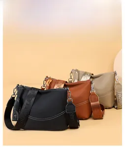 Detailed close-up of textured leather cross-body bags in black, caramel, and khaki colors