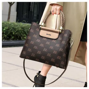 Detail of vintage monogram tote with champagne woven handle and brand logo embossing