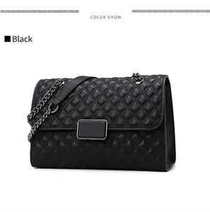 Detalle de bolso bandolera acolchado negro con cadena plateada y cierre de metal