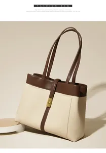 Detail of canvas tote bag showing brown leather trim and golden metal clasp closure