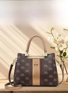 Detail of vintage monogram tote bag with gold metal handle and adjustable crossbody strap