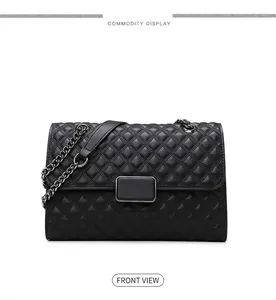 Detalle de bolso bandolera acolchado negro con cadena metálica y cierre rectangular