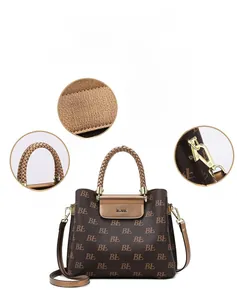 Close-up of monogram pattern, woven handle and gold hardware on dark brown tote bag