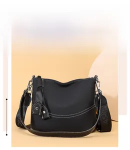 Macro detail of black lychee grain leather handbag with stylish white contrast stitching