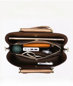 Top view detail of brown tote bag interior with multiple compartments and daily items