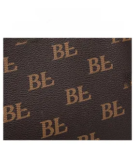 Detailed view of dark brown pebbled faux leather material with monogram pattern print