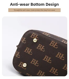 Detail view of tote bag bottom with protective gold studs and logo print texture