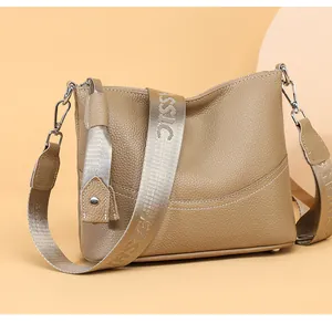 Detail of khaki leather crossbody bag with classic fashion wide fabric shoulder strap
