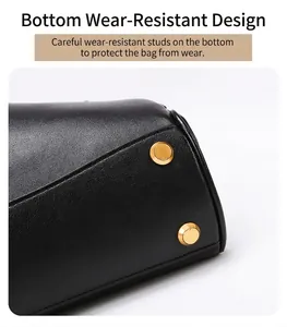 Detailweergave van de zwarte leren shopper met beschermende gouden metalen noppen