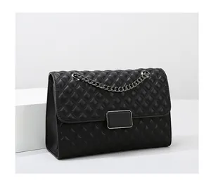 Detalle de bolso acolchado negro con cadena metálica gruesa de alta calidad
