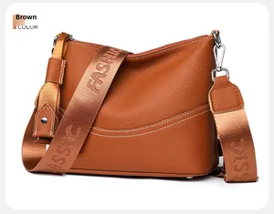 Close-up of brown pebbled leather texture with silver buckles and woven shoulder strap