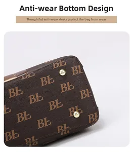 Detail view of gold anti-wear rivets on textured brown monogram leather tote bag base