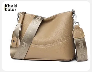 Detail view of khaki pebbled leather shoulder bag with wide embroidered fashion strap