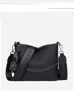 Detailed front view of black leather crossbody bag with lychee texture and logo strap