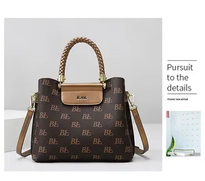 Detail of premium tote bag showing monogram print and woven handles with gold hardware