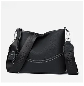 Detail view of black lychee grain leather crossbody bag with letter print wide strap