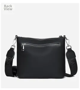 Back view of black pebble leather crossbody bag with silver zipper pocket and logo strap