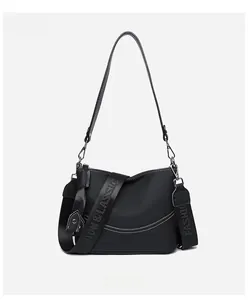 Detail view of leather crossbody bag with white contrast stitching and dual straps