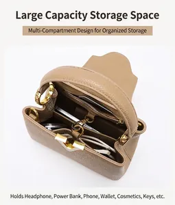Detail view of khaki pebbled leather handbag with interior compartments and gold V-clasp