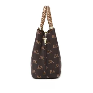 Detailed side view of brown tote bag with BL monogram pattern and braided handle straps