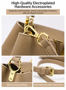 Detail of brown litchi leather handbag with gold metal rings and adjustable strap buckle