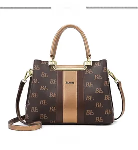 Macro view of monogram pattern tote bag with gold-tone hardware and smooth leather handles
