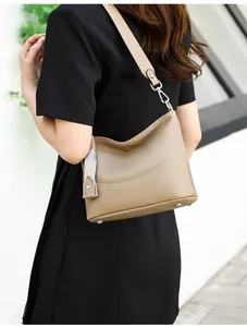 Detail view of khaki leather saddle bag showing side profile and wide shoulder strap