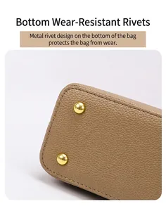 Close-up of pebble leather handbag base with gold protective metal studs and stitching