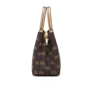 Detail view of large brown monogram tote bag with gold metal handles and side hardware
