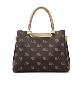 Detail of retro monogram tote bag in dark brown with gold metal hardware accents