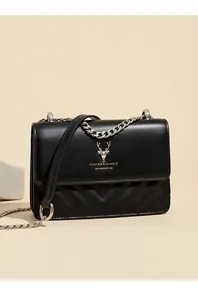 Nahaufnahme der schwarzen gesteppten Ledertasche mit goldenem Hirschlogo und Kette