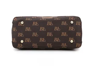 Detailed bottom view of brown monogram tote bag with gold metal protective feet