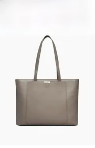 Detail view of the pebbled leather texture and metal accent on a large taupe tote bag