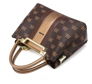 Detailed view of the brown monogram tote bag with gold handles and a zip closure