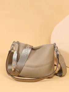 Minimalist beige leather crossbody bag with wide woven strap and large capacity